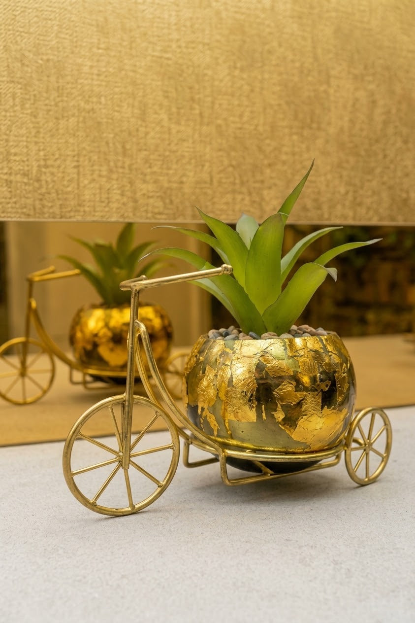 Elegant gold decorative tricycle planter with a textured golden pot, green artificial plant, and stylish metal frame for home and living room decor